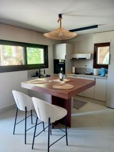 a kitchen with a large wooden table and white chairs at Ianos Living Spaces - 02 in Korinthos