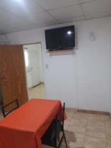 Una habitación con una mesa y un televisor de pantalla plana en el techo. en Alquiler de departamento por dia, en Río Cuarto
