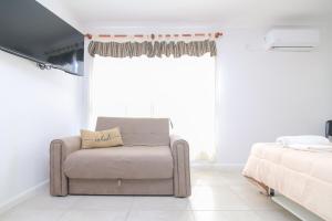 a living room with a couch and a bed at Monoambiente Urquiza I con cochera - Santa Fe in Santa Fe