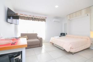 a bedroom with a bed and a couch at Monoambiente Urquiza I con cochera - Santa Fe in Santa Fe