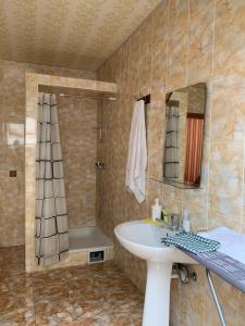 a bathroom with a sink and a shower and a mirror at Hotel Мукачево in Mukacheve +6 photos