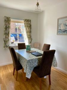 a dining room table with chairs and a laptop on it at May Cottage in Anstruther