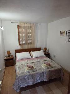 a bedroom with a bed with two towels on it at Mala Basina -Maslina in Vrbanj