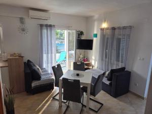 a living room with a table and chairs at Mala Basina -Maslina in Vrbanj