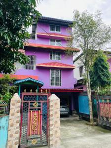 a purple building with a gate in front of it at Sanjukta Homestay in Nowgong