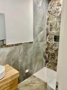a bathroom with a sink and a toilet at Menotti Appartment in Avola +6 photos