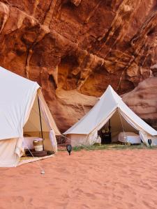 two white tents in front of a cliff at The Legacy of Wadi Rum in Wadi Rum
