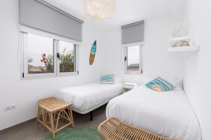 due letti in una stanza con due finestre di Villa Reflejo de Mar a Cotillo Altre 30 foto