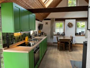 a kitchen with green cabinets and a table at Ferienhaus in Rumke in Bippen