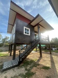 a house with a staircase leading up to it at Wimanthara houses in Thongsala