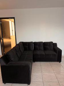 ein schwarzes Ledersofa im Wohnzimmer in der Unterkunft La Casa de las Aguas B&B in Ixmiquilpan