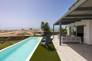 una casa con piscina accanto a una casa di Villa Reflejo de Mar a Cotillo