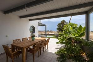 una sala da pranzo con tavolo e sedie in legno di Villa Reflejo de Mar a Cotillo