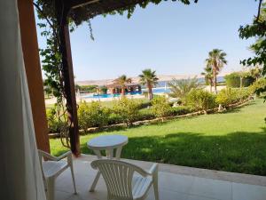 にあるByoum Challet-Tunis villageのプールの景色を望むパティオ(テーブル、椅子付)