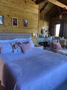 大普拉亚Morro do Eurico - Descanso e privacidade的一间带一张大床的卧室,位于带木墙的房间