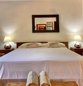 a bedroom with a large white bed with two lamps at Casa Bali Costa Brava in Palafrugell +60 photos