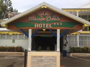 a restaurant with a sign that reads malcolm crab hotel at Hotel La Maison Creole in Le Gosier