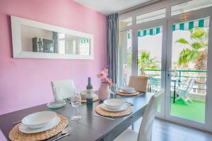 a dining room with pink walls and a table and chairs at Duplex in Playa De Las Américas-center in Playa de las Americas