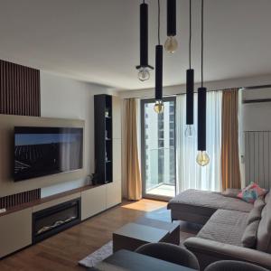 un soggiorno con un divano e una TV di V i N Boutique Apartment a Niš