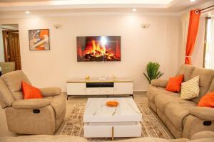 ナクルにあるDreamy Deluxe Apartment Nakuruの2つのソファと暖炉のあるリビングルーム