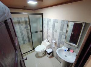 une salle de bains avec douche, toilettes et lavabo dans l'établissement Corcovado Paradise Lodge, à Drake