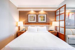 a hotel room with a bed and a chair at MGM Signature 19-716 Jacuzzi Studio in Las Vegas +4 photos