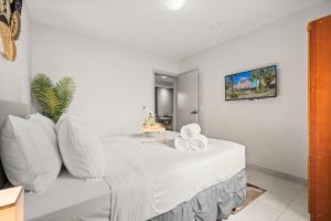 a white bed with white pillows in a room at 2br Aruba Comfort Retreat W Pool, Bbq & Gated! in Pos Abao +26 photos