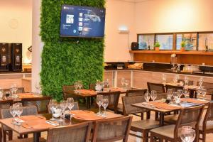 a dining room with tables and a green wall at Luxo na Beira Mar - Beach Class Executive 105 in Recife