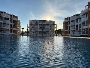 a pool in front of some apartment buildings at Nouvel appartement élégant à Cabo - Vue sur la piscine et proche de la plage in Cabo Negro +29 photos