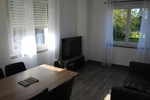 a living room with a table and a television at Le Nid - 2 Bedrooms - Myra Conciergerie in Gan