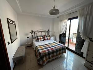 a bedroom with a bed and a large window at Duplex El Principito in Gran Tarajal
