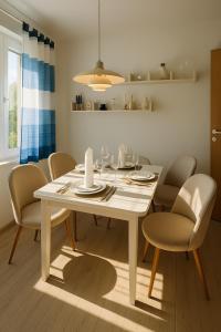 a dining room with a white table and chairs at Ferienwohnung Wulf Sylt EG in Wenningstedt