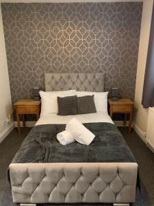 a bedroom with a large bed with a gray headboard at The Rossiter - City Centre Pad in Bath