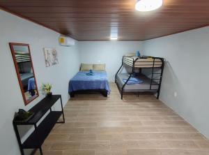 - une chambre avec un lit et des lits superposés dans l'établissement Corcovado Paradise Lodge, à Drake