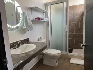 a bathroom with a sink and a toilet and a mirror at Casa 3 Bugambilia de Villa Verde in Chiquimula +10 photos