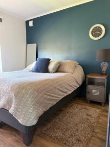 a bedroom with a bed and a clock on the wall at Moderna casa con piscina e internet de alta velocidad en Talca in Talca