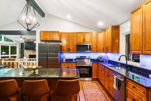 eine Küche mit Holzschränken und einer schwarzen Arbeitsplatte in der Unterkunft Pocono Speak Easy Hot Tub Golf Simulator 1920 Bar in Mount Zion