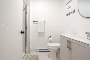 a white bathroom with a toilet and a sink at Theatre Hotel by Lodgo in Montréal +91 photos