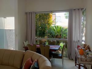 a living room with a couch and a table and a large window at Casa Cop30 Belém in Belém
