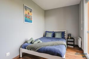 Schlafzimmer mit einem Kingsize-Bett und blauer Bettwäsche in der Unterkunft Montaigne - Proche Tram - 5min Aéroport in Blagnac