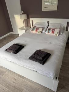 a large white bed with three pillows on it at An Dorzell beach 60 meters in Cléder