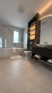 a bathroom with a tub and a toilet and a sink at Stylish House in Suceava