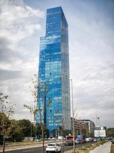 a tall glass building with cars parked in front of it at Star West Luxury in Belgrade