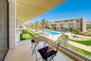 a balcony with a table and chairs and a view of a pool at G-Cribs El Gouna - Apartments with Pool Access in El Gouna +75 photos
