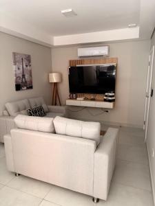 a living room with a couch and a flat screen tv at Apartamento amoblado cerca del aeropuerto Silvio Pettirossi in Asuncion