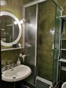 ein Badezimmer mit Waschbecken und Dusche mit Spiegel in der Unterkunft Alpine Luck Apartment, Sella Nevea in Sella Nevea