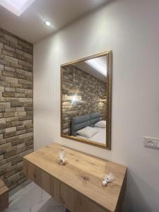 a mirror on a wall with a bed in a room at Dolphin Hotel Apartments in Karpathos Town