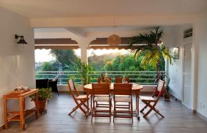 a dining room with a table and chairs and a large window at Terrasses ouvertes sur la mer in Schœlcher