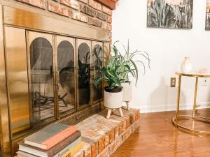 a living room with a brick fireplace with a potted plant at Tally Town Gem 2bdr 2 Ba townhome in Perkins +24 photos