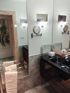 Un baño con un lavabo negro y un espejo. en Domus Chiara al Colosseo, en Roma 55 fotos más